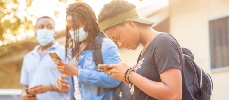 Jeunes africains portant des masques et observant le protocole de distance sociale pendant la pandémie de COVID-19.